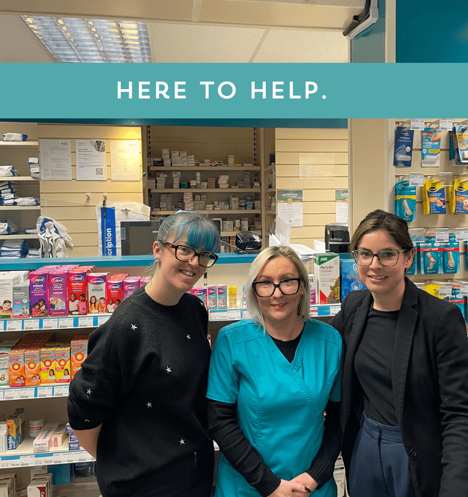 Our pharmacist and pharmacy dispensers stand in the pharmacy behind the counter, the shop shelves visible in the background. Text overlay says 'here to help'.