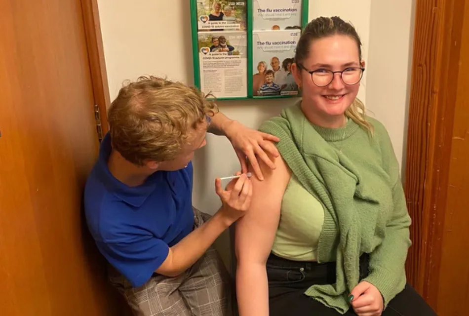 A photo of a patient smiling whilst being vaccinated in one of our pharmacy consulting rooms.