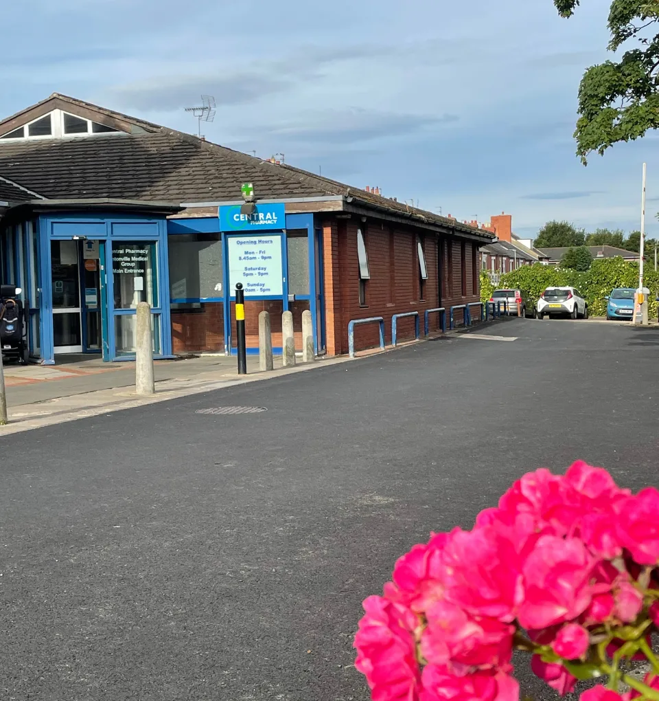 Central Pharmacy-external Central Pharmacy and Lintonville Surgery with pretty flower in the foreground.